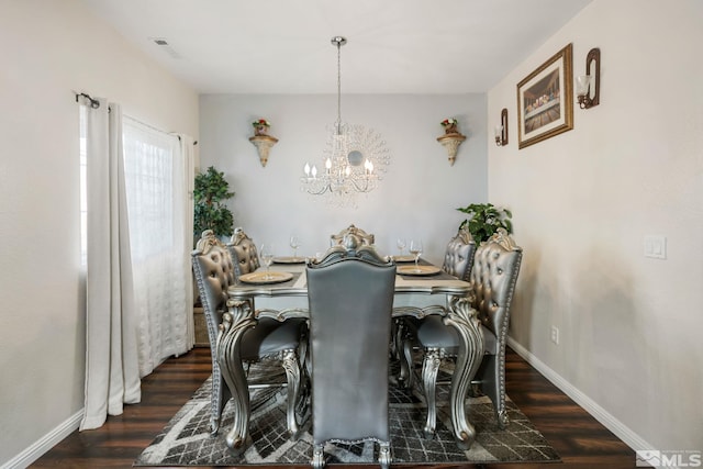 dining area featuring a notable chandelier, visible vents, baseboards, and wood finished floors