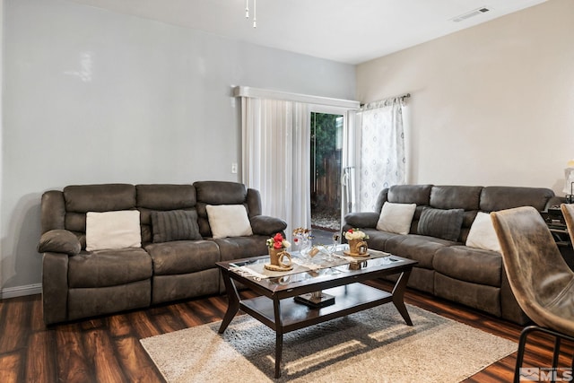 living area featuring visible vents and dark wood-type flooring