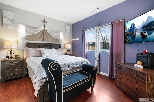 bedroom featuring visible vents, baseboards, and wood finished floors
