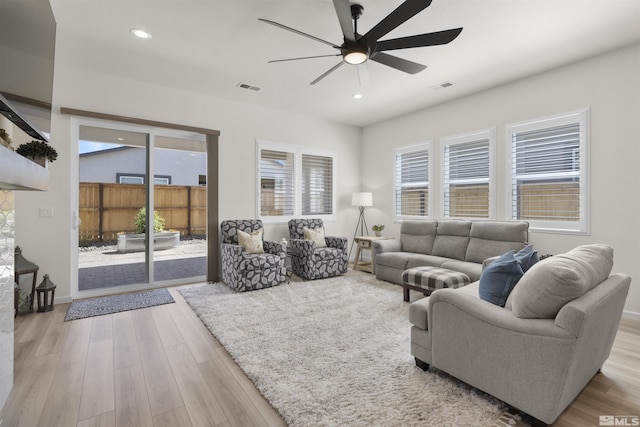 living area featuring visible vents, ceiling fan, and wood finished floors