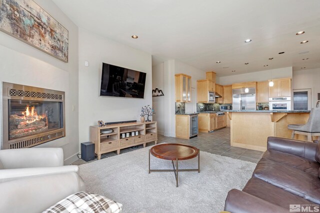 living room featuring tile patterned floors, a glass covered fireplace, and recessed lighting