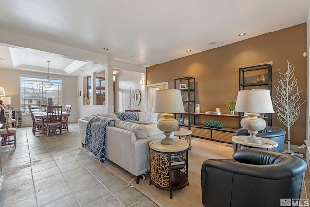 tiled living area featuring recessed lighting, a tray ceiling, and decorative columns