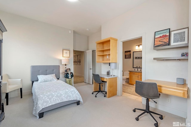 bedroom featuring light carpet, built in desk, and a sink