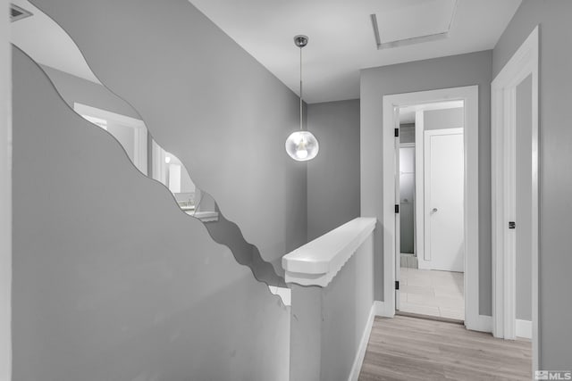 stairway with wood finished floors, visible vents, and baseboards