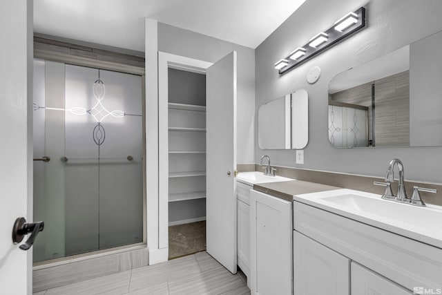 bathroom with double vanity, an enclosed shower, and a sink