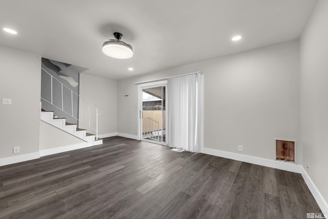 spare room featuring dark wood finished floors, recessed lighting, and baseboards