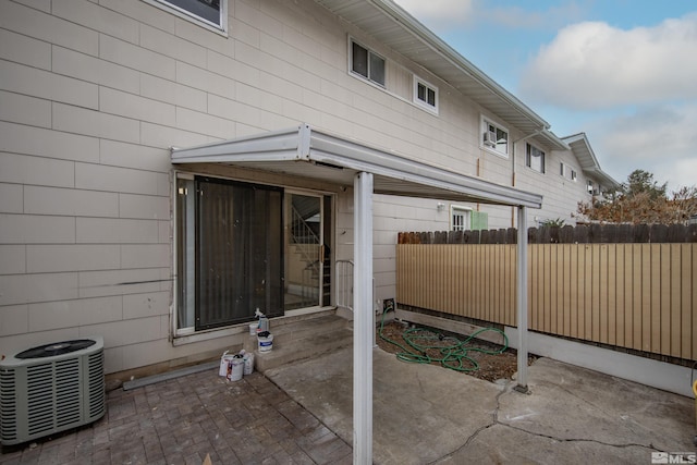 exterior space with cooling unit and fence
