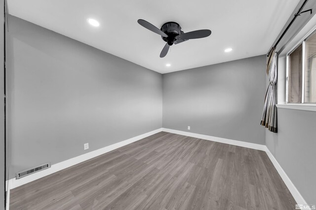 unfurnished room featuring wood finished floors, baseboards, visible vents, recessed lighting, and ceiling fan
