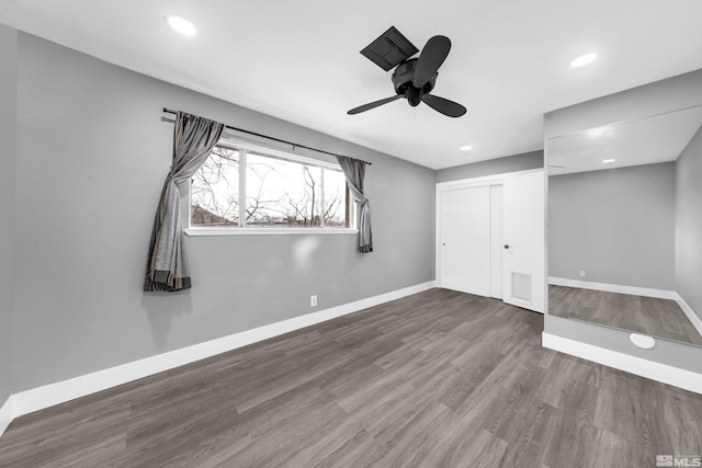 unfurnished bedroom with recessed lighting, a closet, baseboards, and wood finished floors