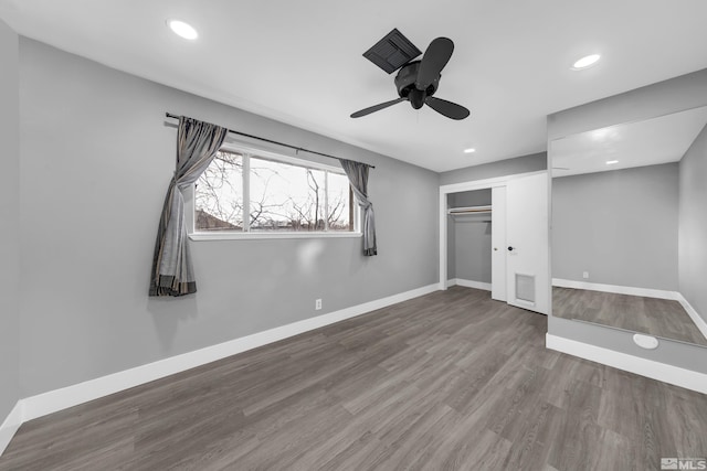 unfurnished bedroom with recessed lighting, wood finished floors, baseboards, and a closet