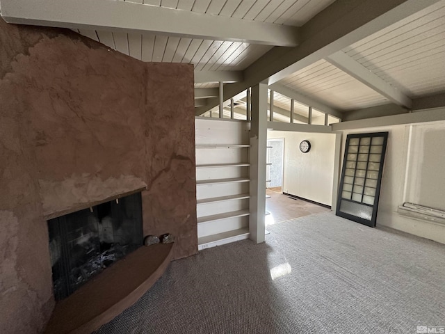 unfurnished living room featuring carpet flooring, a fireplace, wood ceiling, and lofted ceiling with beams