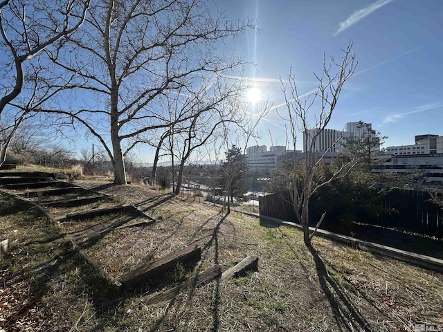 view of yard featuring a view of city and fence