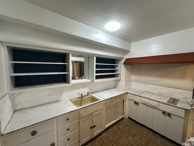 kitchen featuring a sink, open shelves, and dark floors