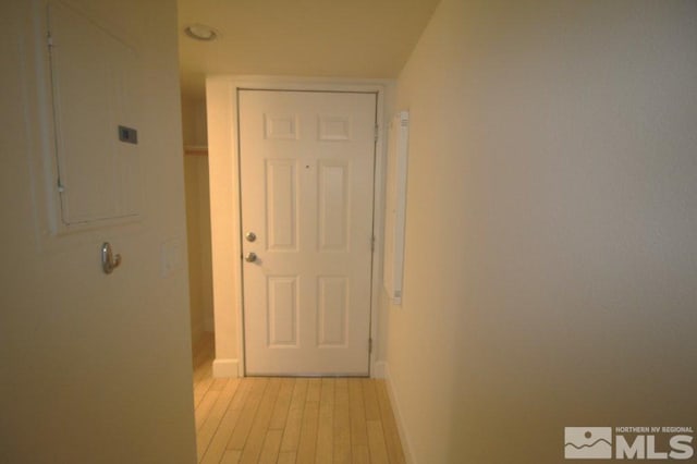 hall with baseboards and light wood-style floors