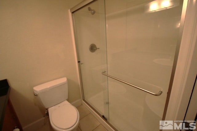 bathroom with tile patterned flooring, a shower stall, and toilet