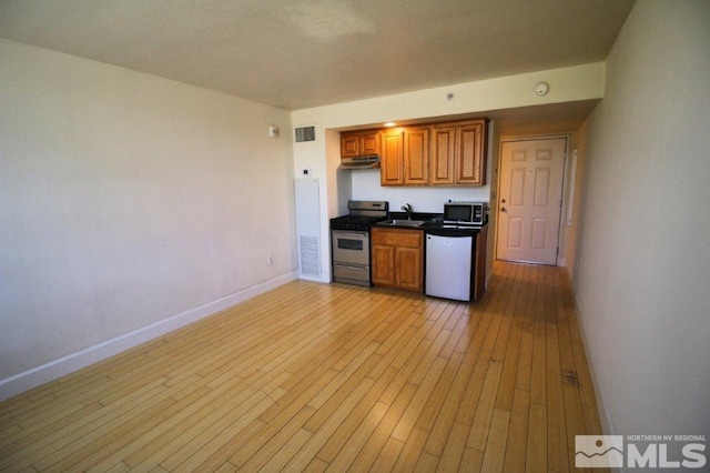 kitchen with dishwasher, a sink, black microwave, baseboards, and stainless steel stove