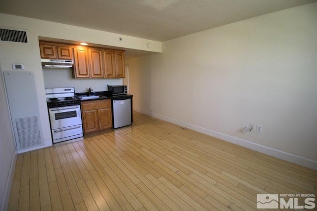 kitchen featuring electric range oven, under cabinet range hood, visible vents, and dishwashing machine