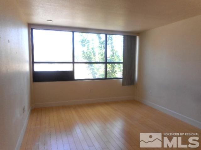 unfurnished room featuring baseboards and light wood-style floors