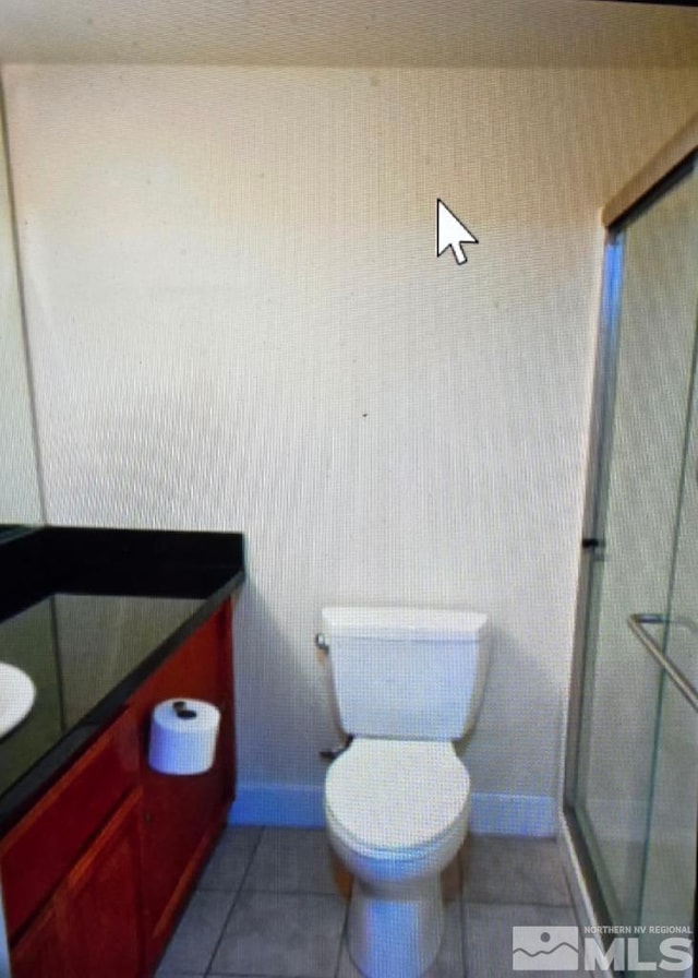 full bath featuring a shower stall, toilet, vanity, and tile patterned floors