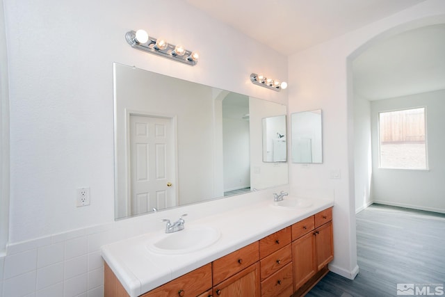 bathroom with double vanity, wood finished floors, and a sink