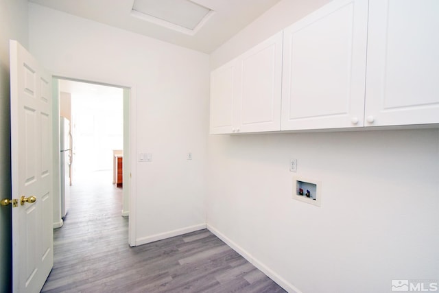 laundry room with washer hookup, baseboards, wood finished floors, attic access, and cabinet space