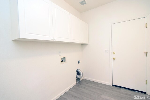 clothes washing area with hookup for a washing machine, baseboards, visible vents, light wood-style flooring, and cabinet space