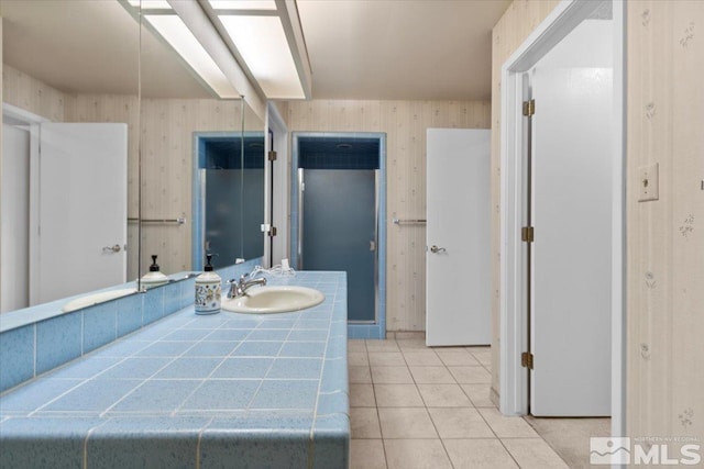 bathroom with tile patterned flooring, wallpapered walls, and vanity