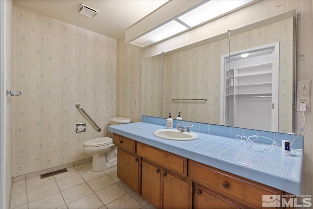 bathroom featuring tile patterned flooring, visible vents, and wallpapered walls