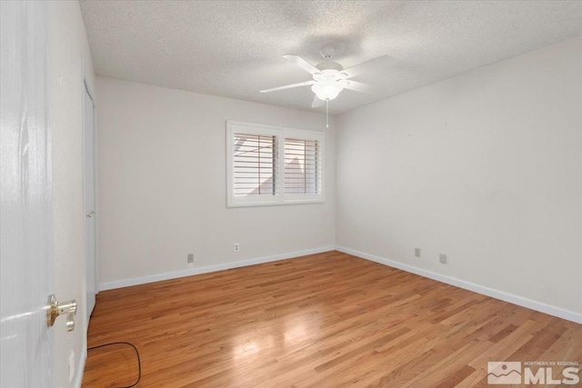 empty room featuring baseboards, light wood-type flooring, and a ceiling fan