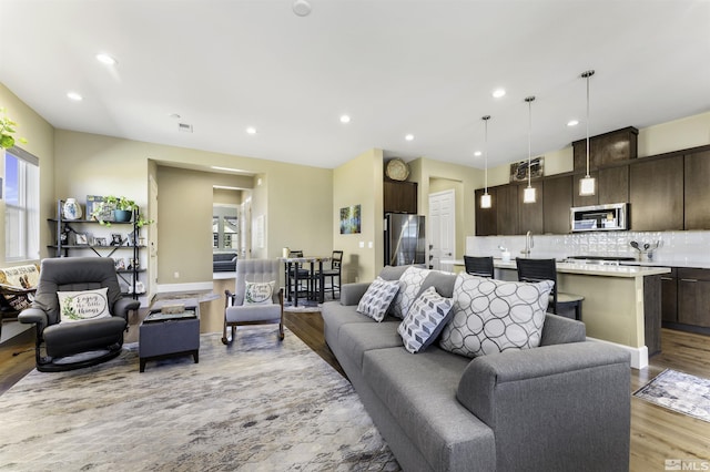 living area with recessed lighting and light wood-style flooring