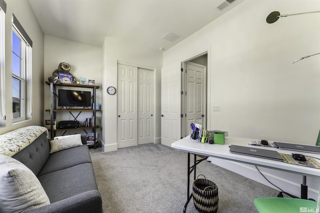 carpeted office space featuring visible vents and baseboards