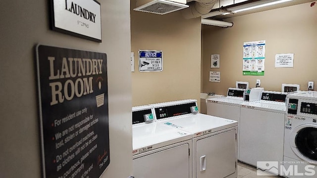 shared laundry area with visible vents, washing machine and dryer, and light tile patterned flooring