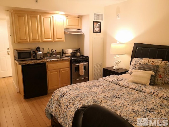 bedroom with a sink, light wood-type flooring, and visible vents