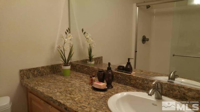 full bathroom featuring vanity, toilet, and a stall shower
