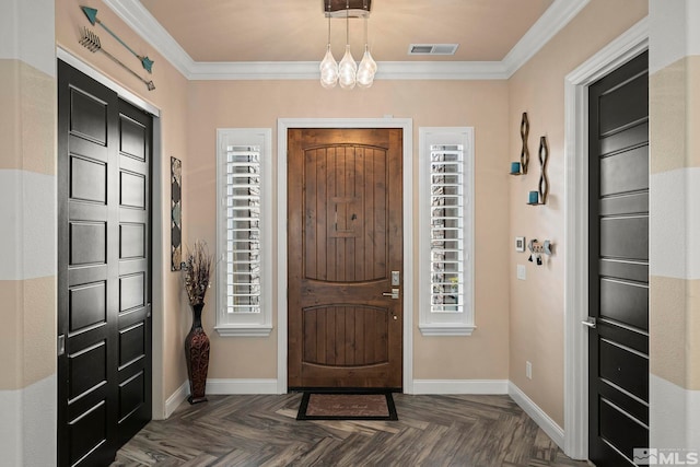 foyer entrance featuring baseboards, visible vents, crown molding, and a chandelier