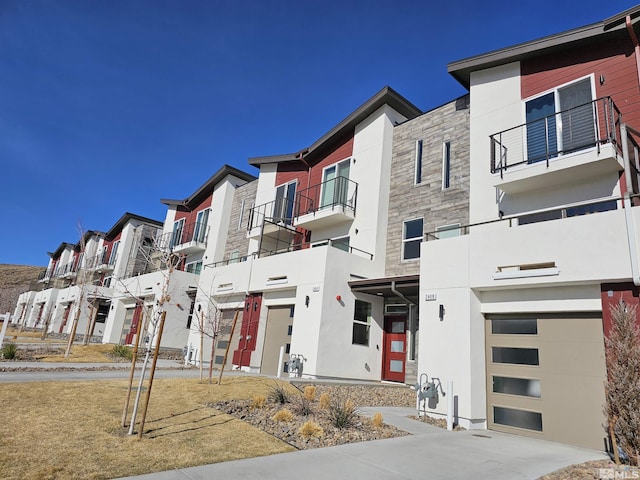 view of building exterior with a residential view, driveway, and a garage