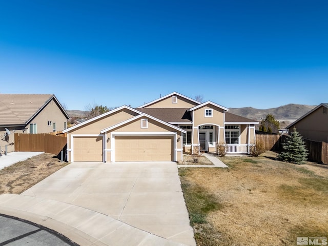 view of front of property with concrete driveway, fence, a mountain view, covered porch, and a garage