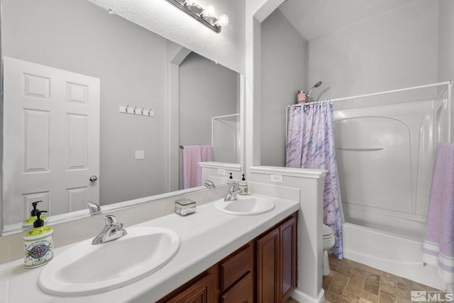 bathroom with shower / bath combination with curtain, a sink, stone finish floor, and toilet