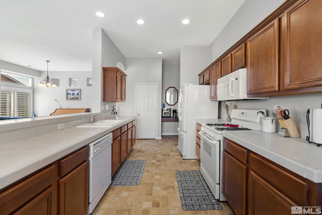kitchen featuring a sink, recessed lighting, a chandelier, and white appliances