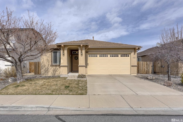 view of front of property with fence, driveway, stucco siding, and a garage