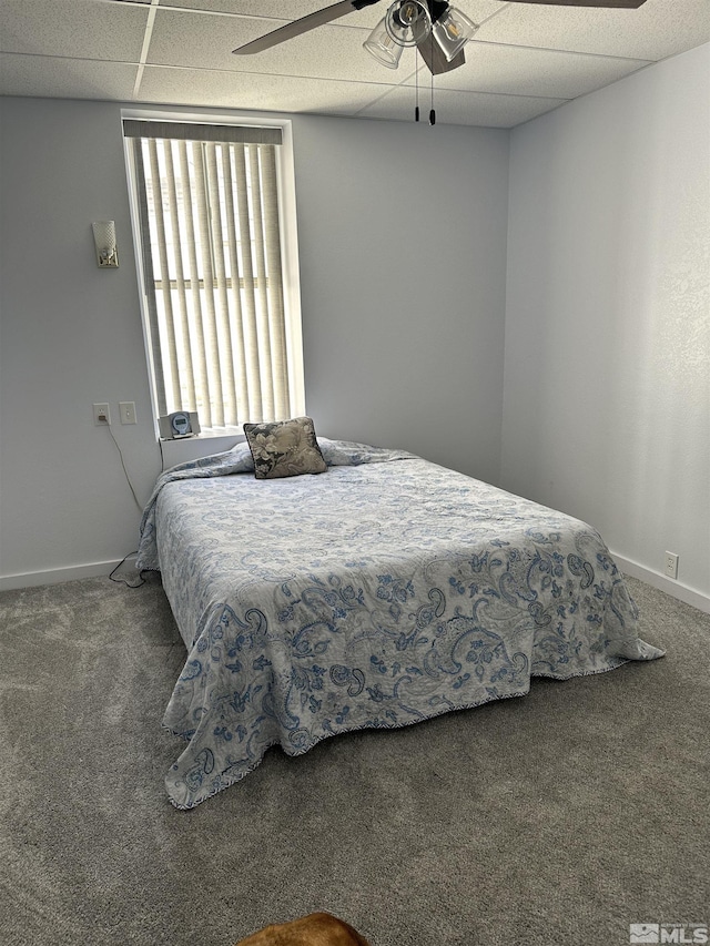 bedroom with baseboards, carpet floors, and a drop ceiling