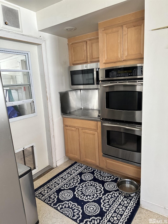 kitchen featuring light speckled floor, appliances with stainless steel finishes, and visible vents