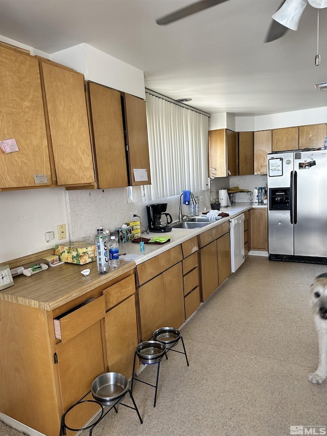 kitchen with a sink, a ceiling fan, dishwasher, light floors, and stainless steel refrigerator with ice dispenser