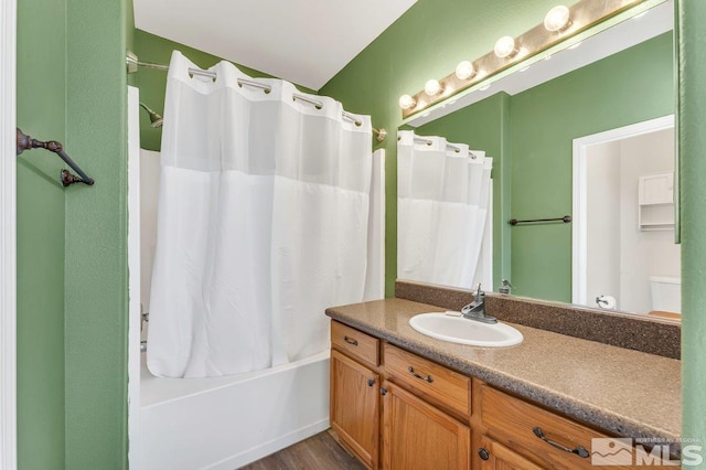 full bath featuring shower / tub combo with curtain, wood finished floors, and vanity