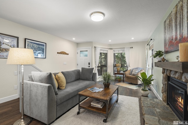 living area featuring recessed lighting, baseboards, a fireplace, and wood finished floors