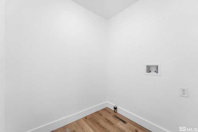 washroom with visible vents, hookup for a washing machine, baseboards, laundry area, and light wood-type flooring