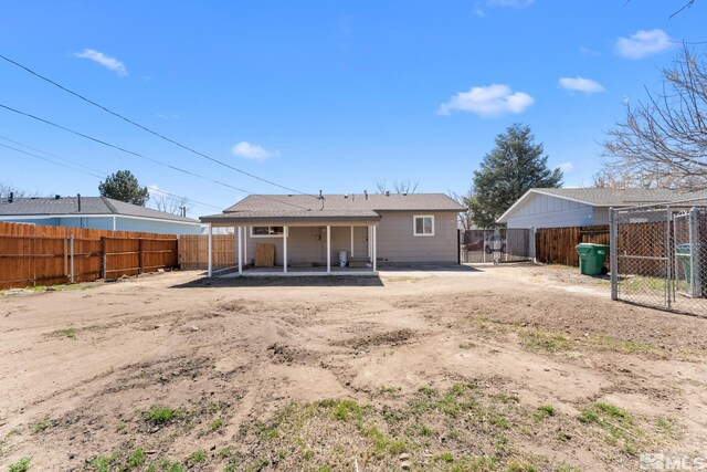 back of property featuring a fenced backyard, a gate, and a patio