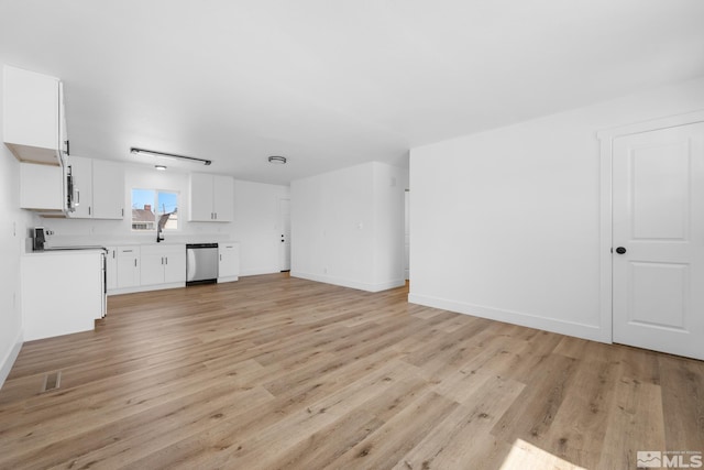 unfurnished living room with baseboards, visible vents, and light wood-style flooring