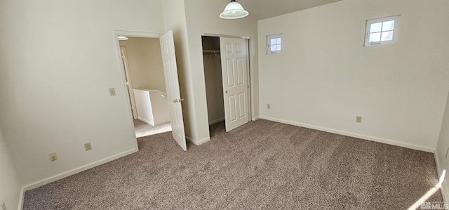 unfurnished bedroom with baseboards, carpet floors, and a closet