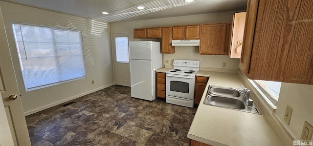 kitchen with light countertops, a sink, brown cabinets, under cabinet range hood, and white appliances